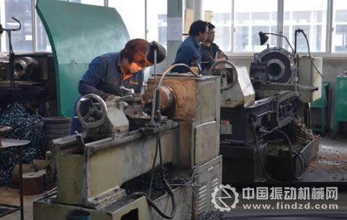 圖為工作人員在生產車間現場加工礦山機械產品零件。